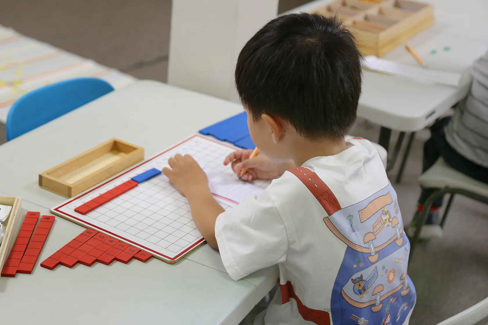 Child engaged in hands-on Montessori mathematics work